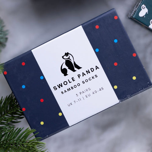 Box of Swole Panda bamboo socks with decorative polka dots on a neutral background