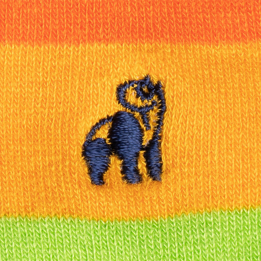 Embroidered blue monkey design on orange and green striped fabric