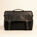 Black leather satchel bag on a beige background