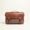 Brown leather and gray fabric satchel bag on a beige background