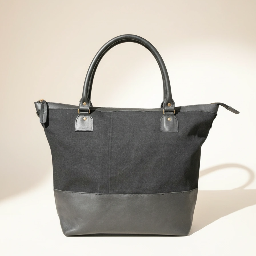 Gray tote bag with leather accents on a beige background