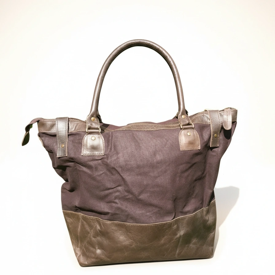 Brown tote bag with leather accents on a white background