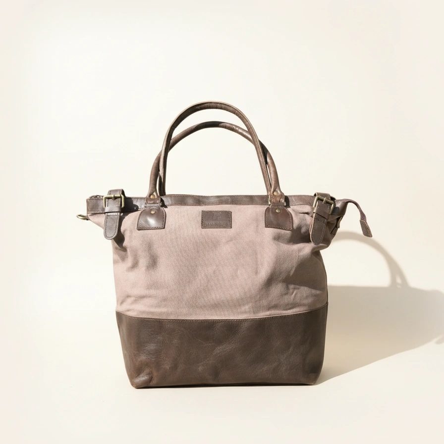 Gray tote bag with leather straps on a light beige background