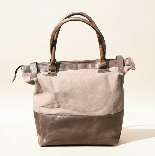 Two-toned handbag with beige top half and brown bottom half on a light background