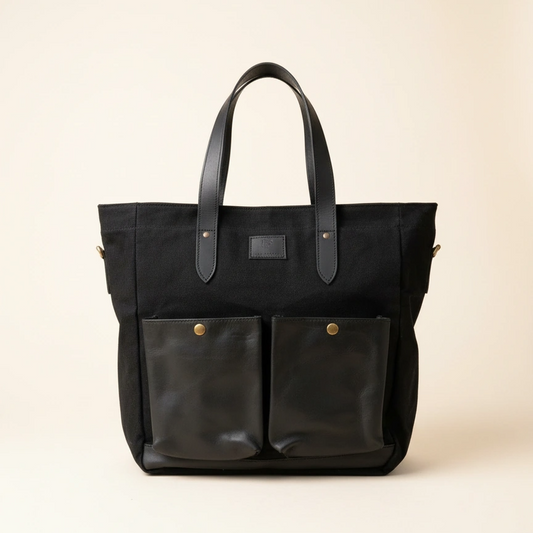 Black tote bag with leather accents on a beige background