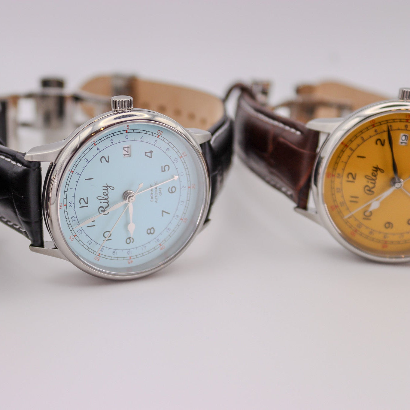 Three watches with different colored faces on a white background