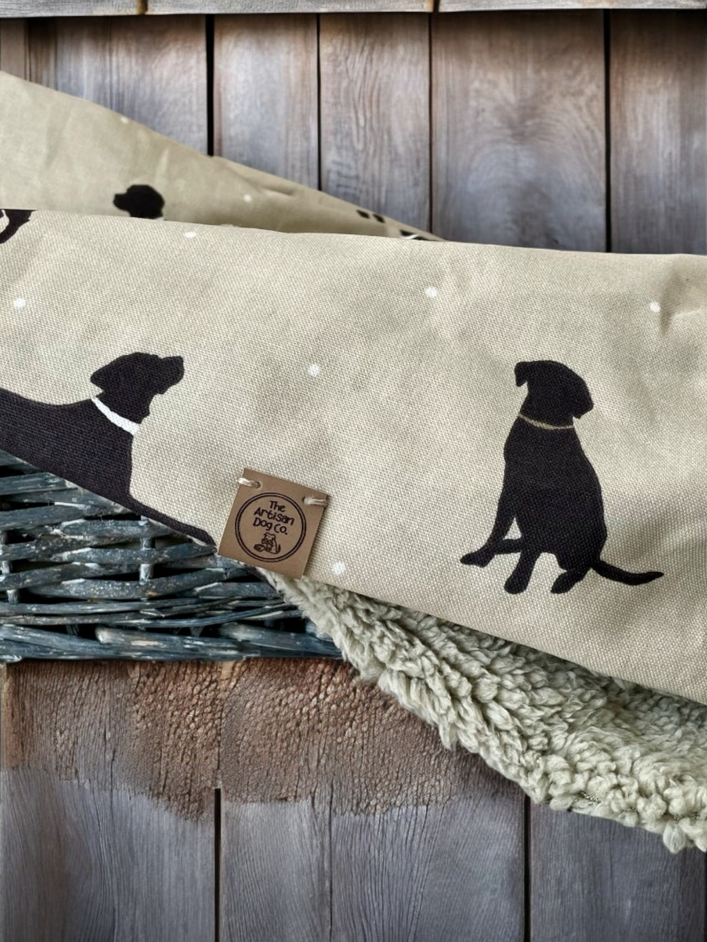 Fabric with black dog silhouette on beige background, placed on a wooden surface.