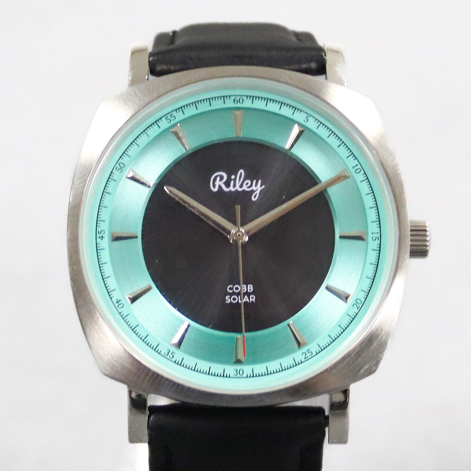 Wristwatch with black strap and turquoise dial on a white background