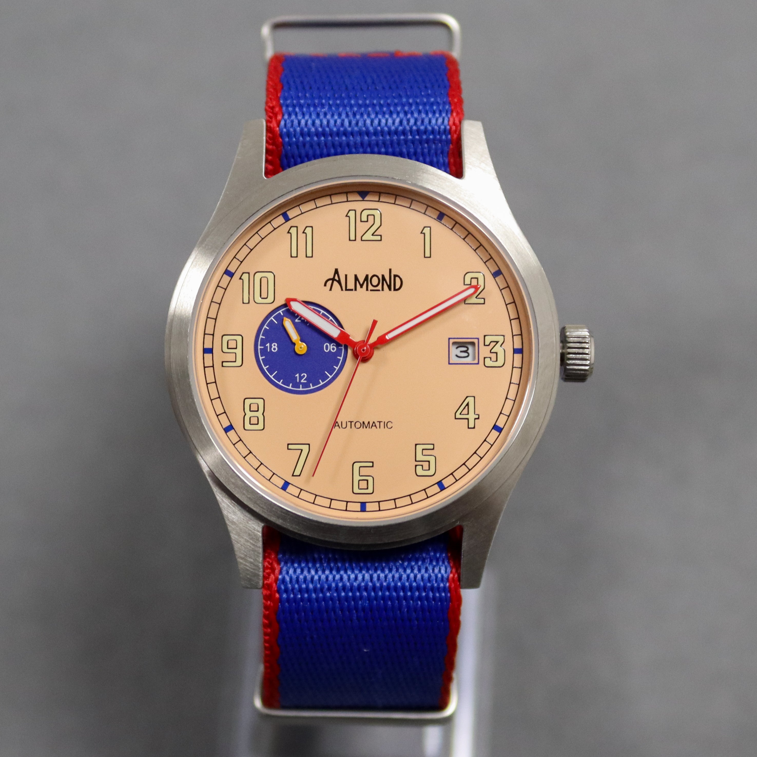 Watch with a blue strap and beige face on a gray background