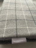 Gray checkered fabric with a label reading 'The Artisan Dog Co.'