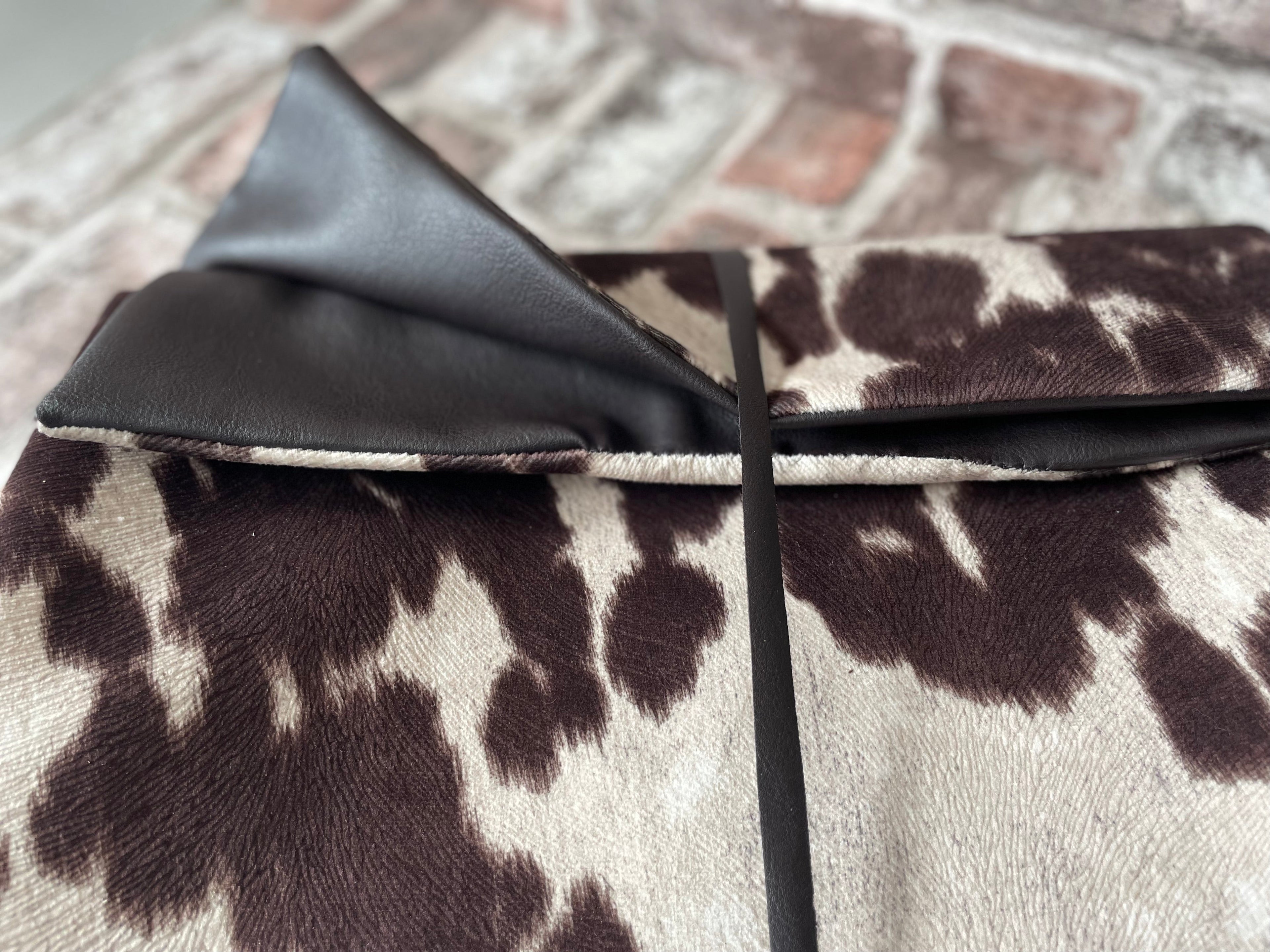 Close-up of a brown and white patterned fabric with a black border.