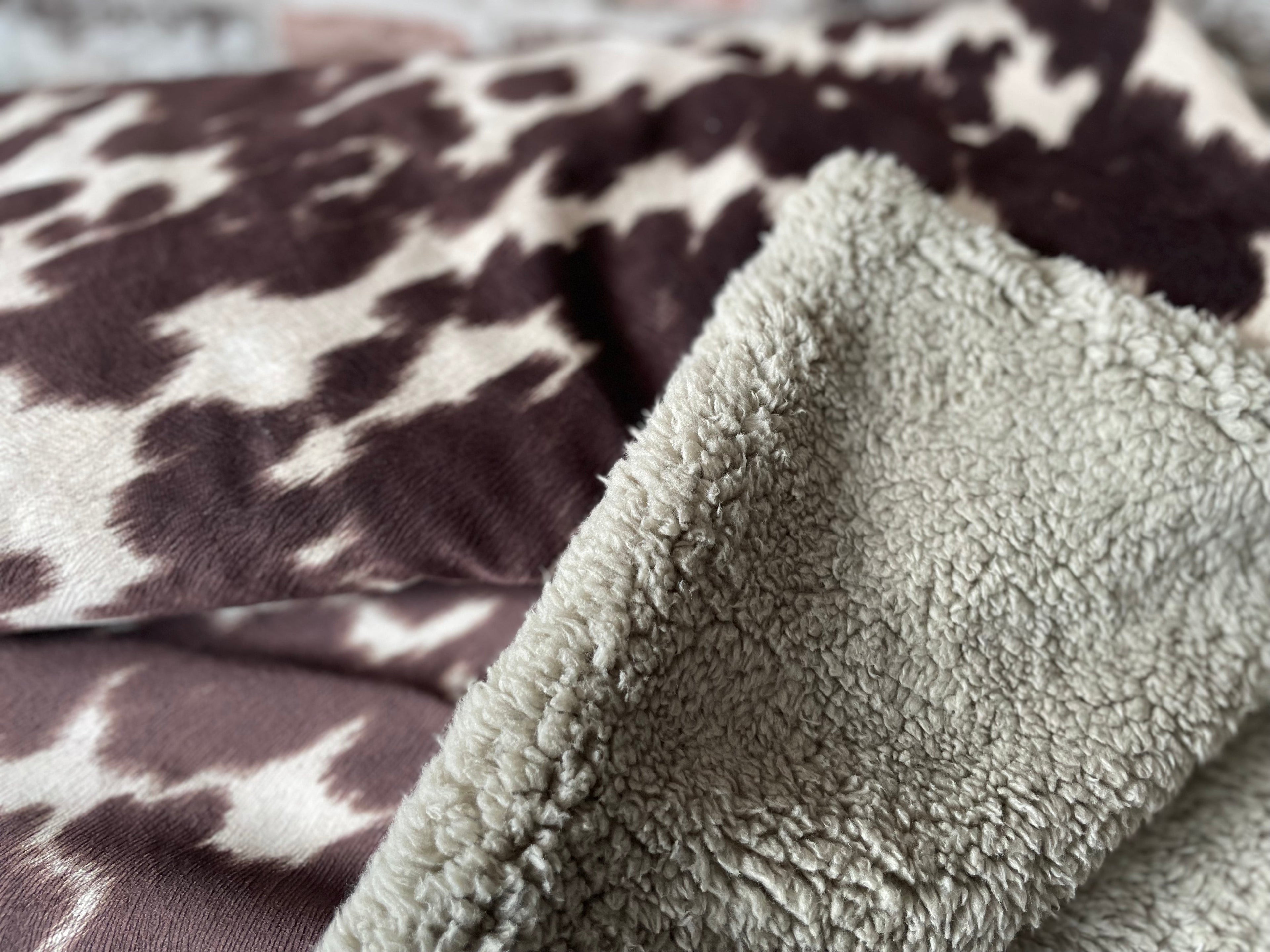 Close-up of a textured gray blanket on a patterned fabric background
