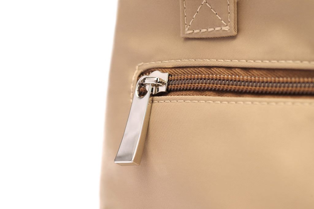 Close-up of a beige bag with a zipper on a white background