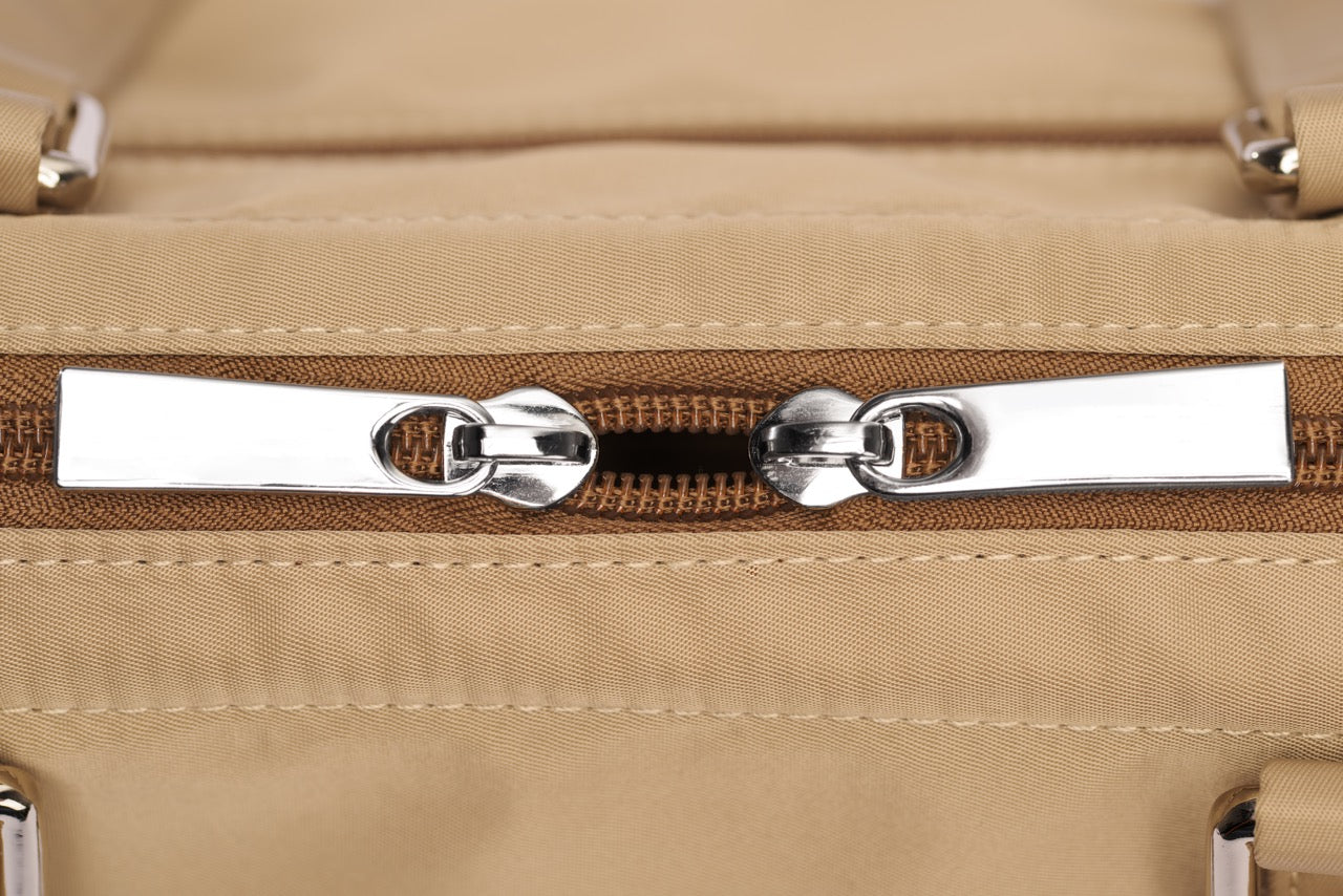 Close-up of a beige suitcase with a zipper
