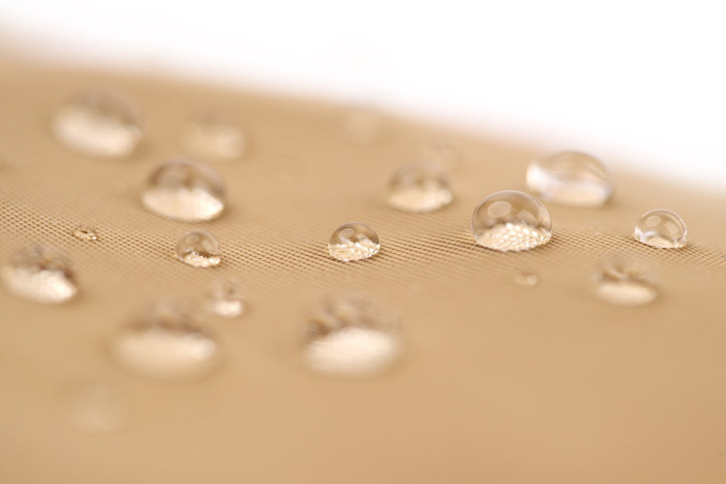 Close-up of water droplets on a textured beige surface