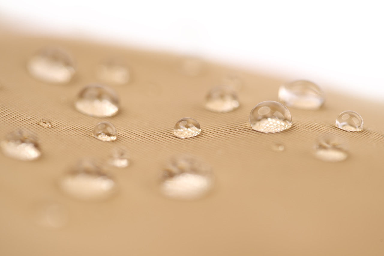 Close-up of water droplets on a textured beige surface