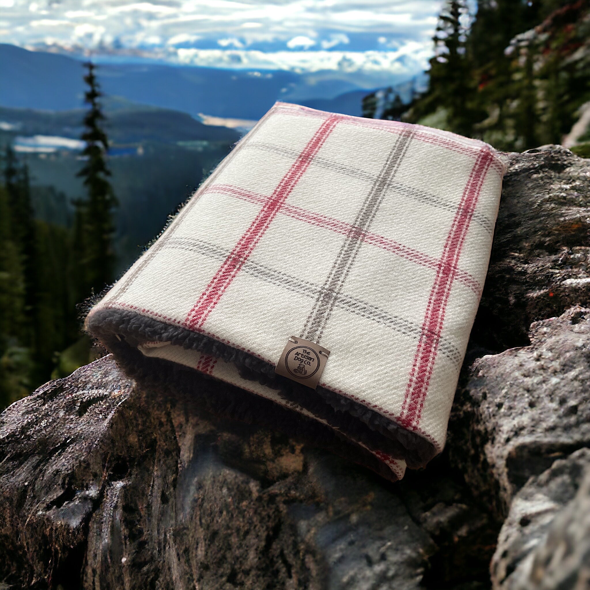 Plaid blanket on a rock with a mountainous landscape in the background