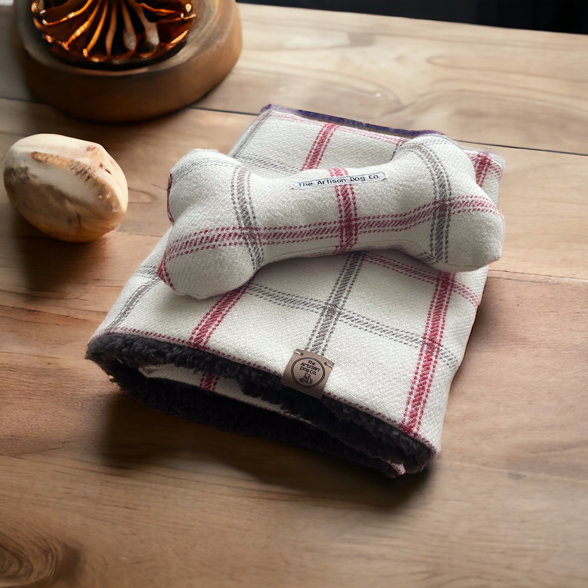 Checkered dog bed with plush lining on a wooden surface