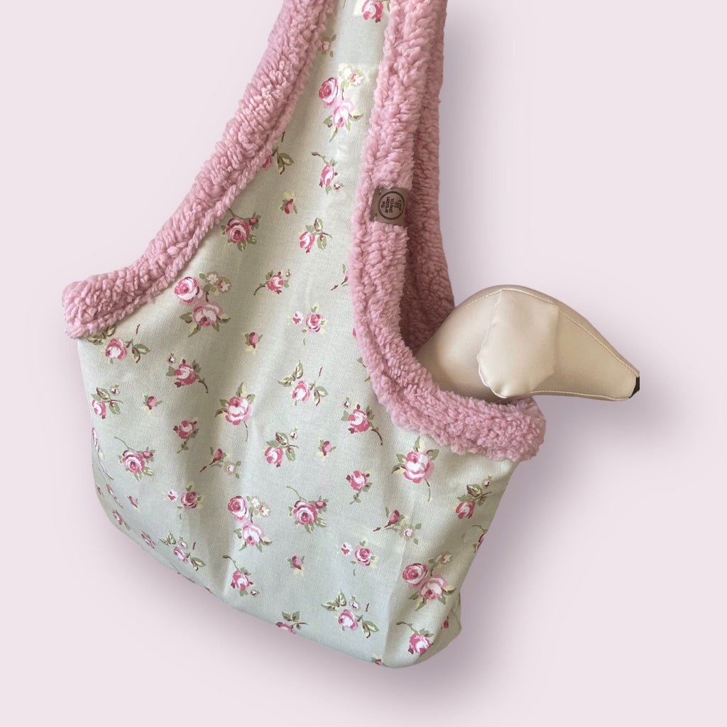 Floral-patterned bag with pink trim on a light pink background