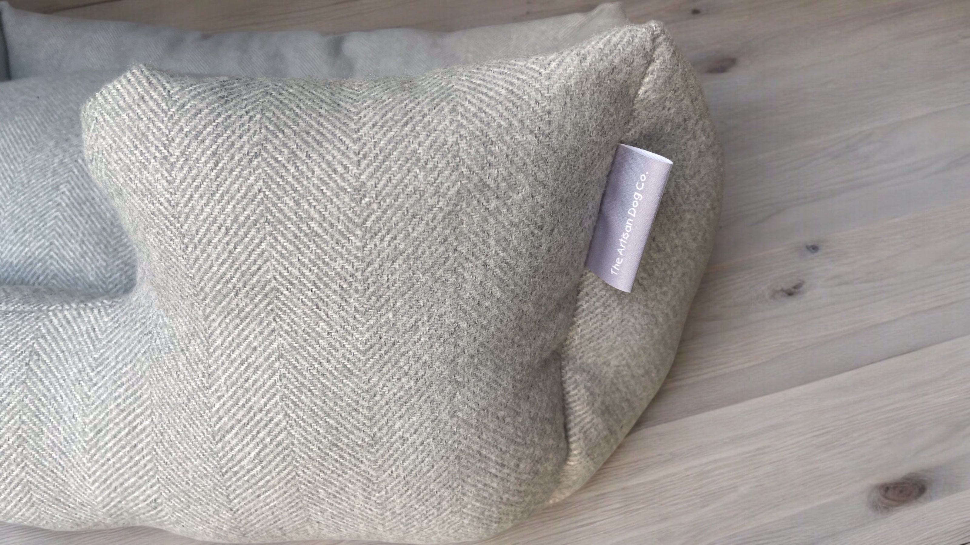 Textured pillow with a brand tag on a wooden surface