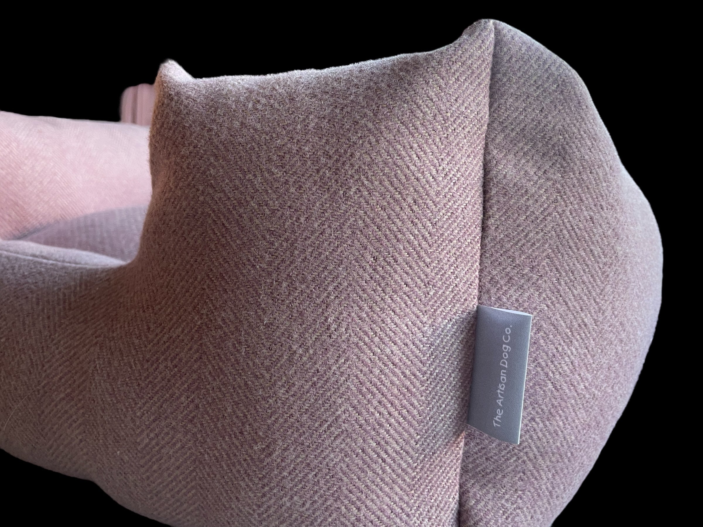 Textured pillow with a brand tag on a black background
