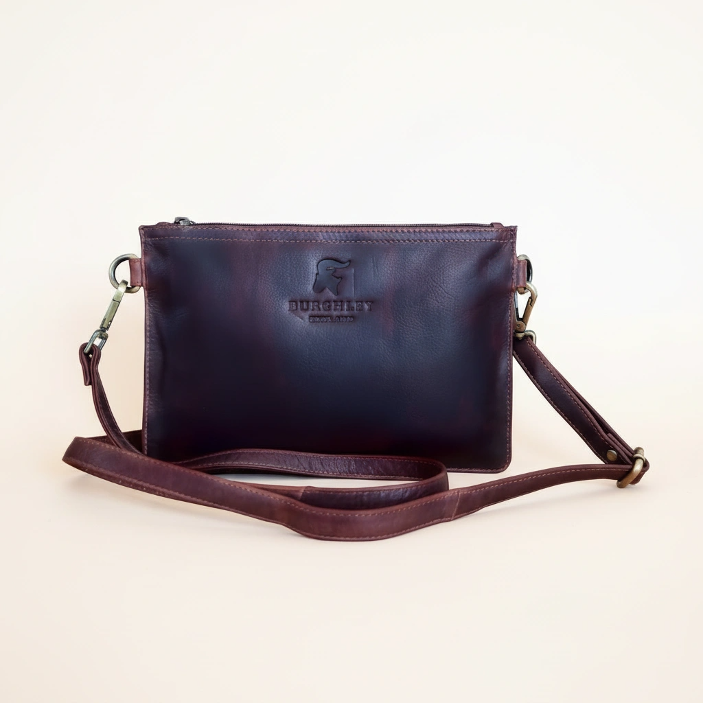 Brown leather crossbody bag with visible brand logo on a light beige background