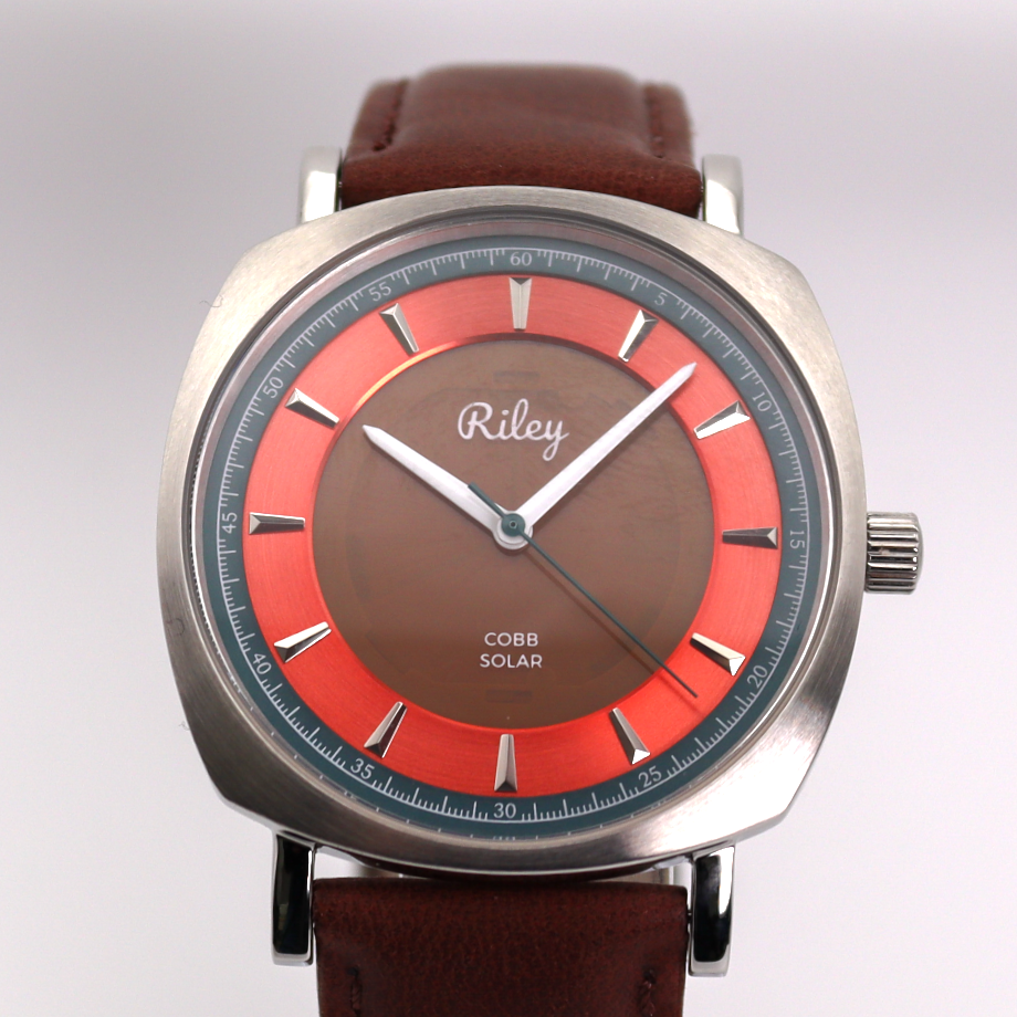 Wristwatch with a brown strap and red face on a white background