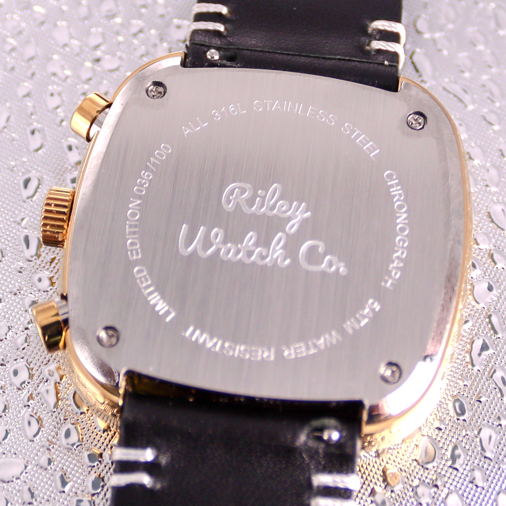 Back view of a watch with 'Riley Watch Co' engraving on a textured gray background