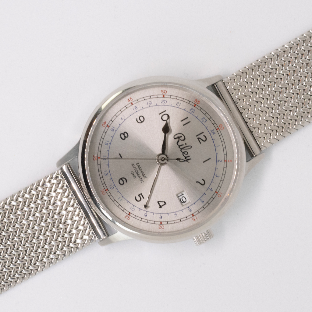 Silver watch with mesh band on a white background