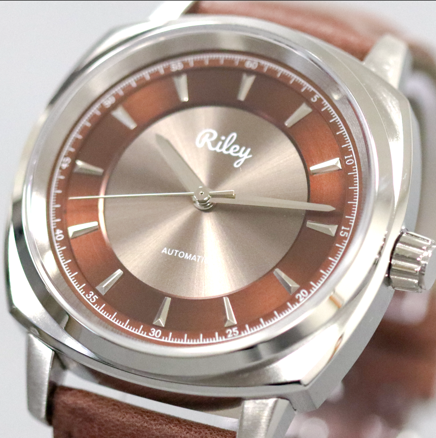 Watch with brown face and leather strap, featuring the brand 'Riley'.