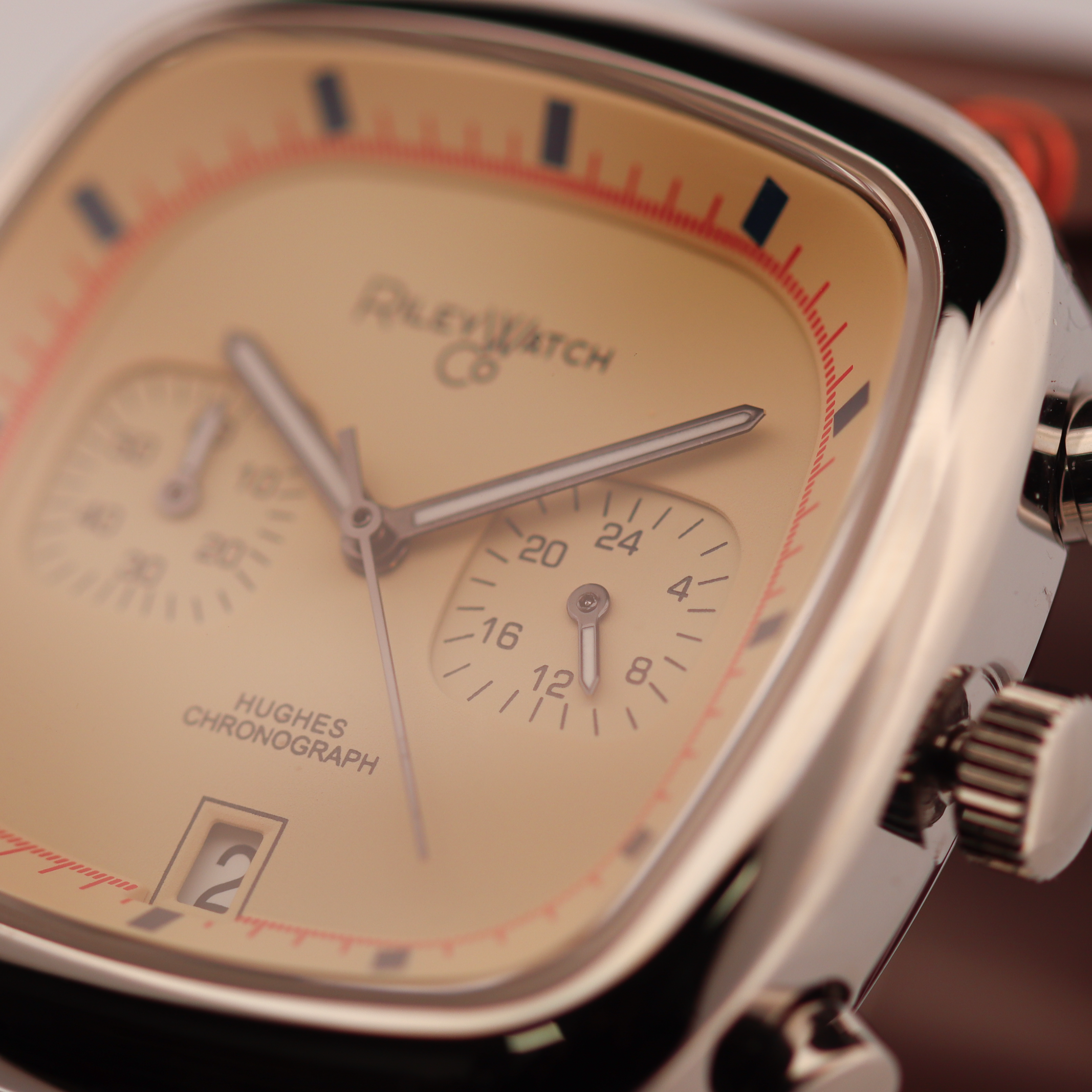 Close-up of a Plevé watch with a gold face and silver case.