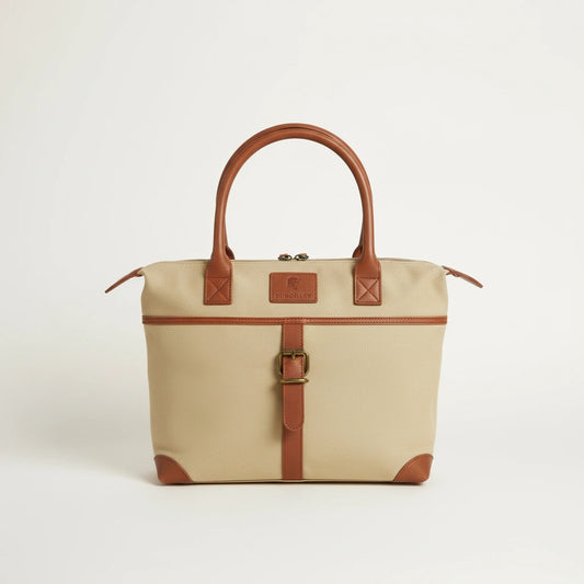 Beige handbag with brown leather straps and handle on a light gray background