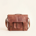 Brown leather satchel bag on a beige background
