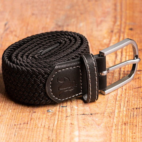 Black woven belt with leather buckle on a wooden surface