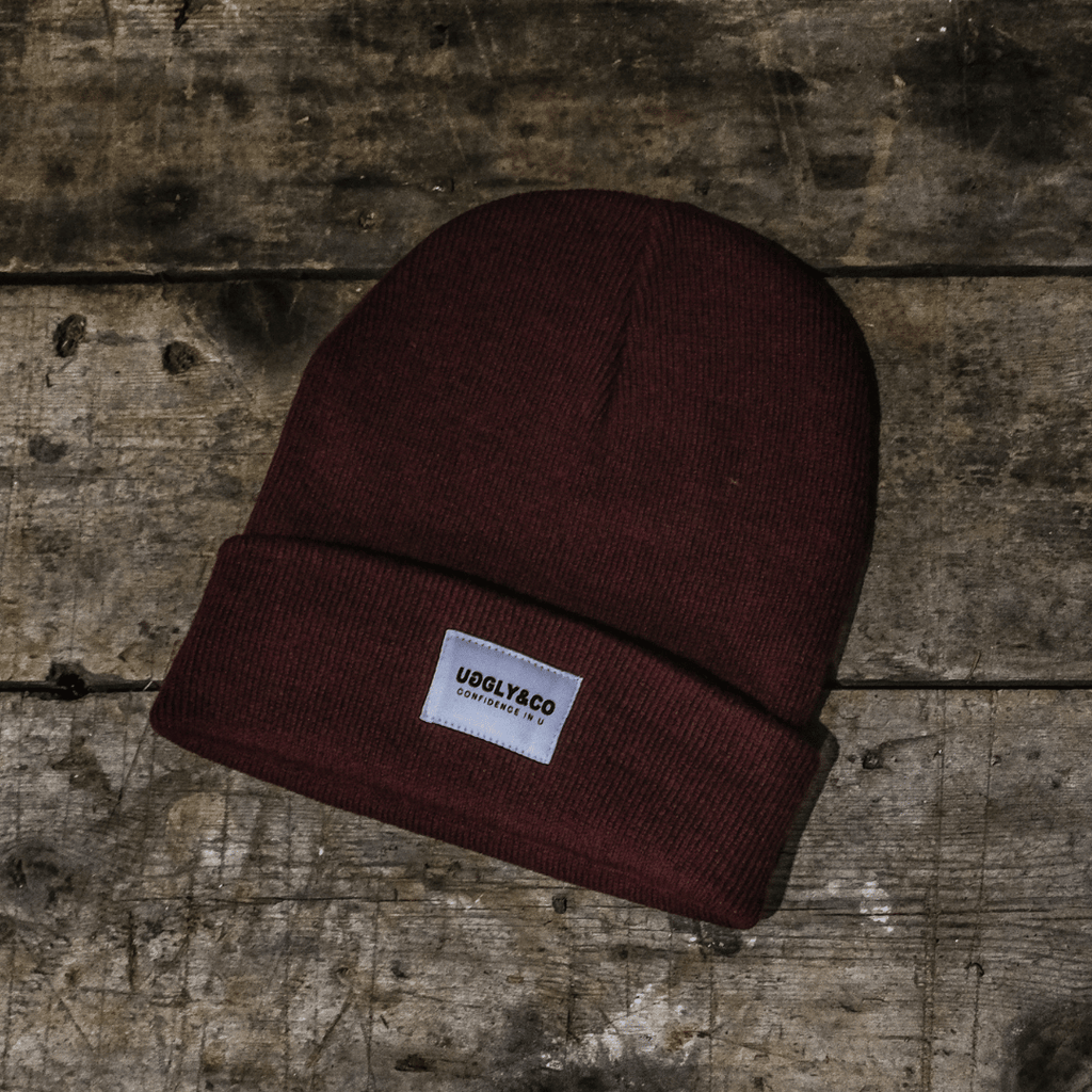Brown beanie with a label on a wooden surface