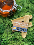 Himalayan Yak Milk Natural Dog Chews with a jar of honey on a green moss background
