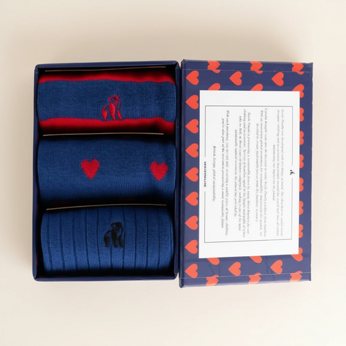Blue socks with red heart and black silhouette design in a box with heart pattern