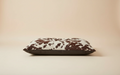 Cow print pillow on a beige background