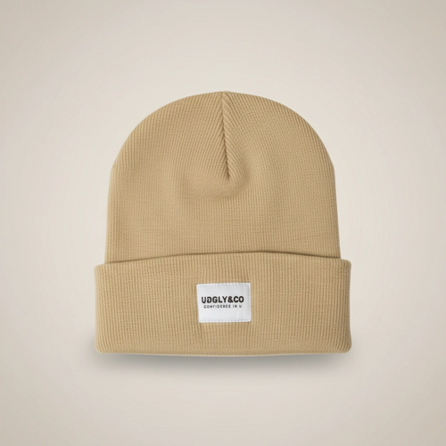 Beige beanie with a label on a beige background