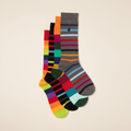 Two pairs of socks, one colorful and one with stripes, on a beige background.