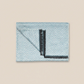 Folded fabric with blue chevron pattern on a beige background