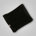 Folded black blanket on a light gray background