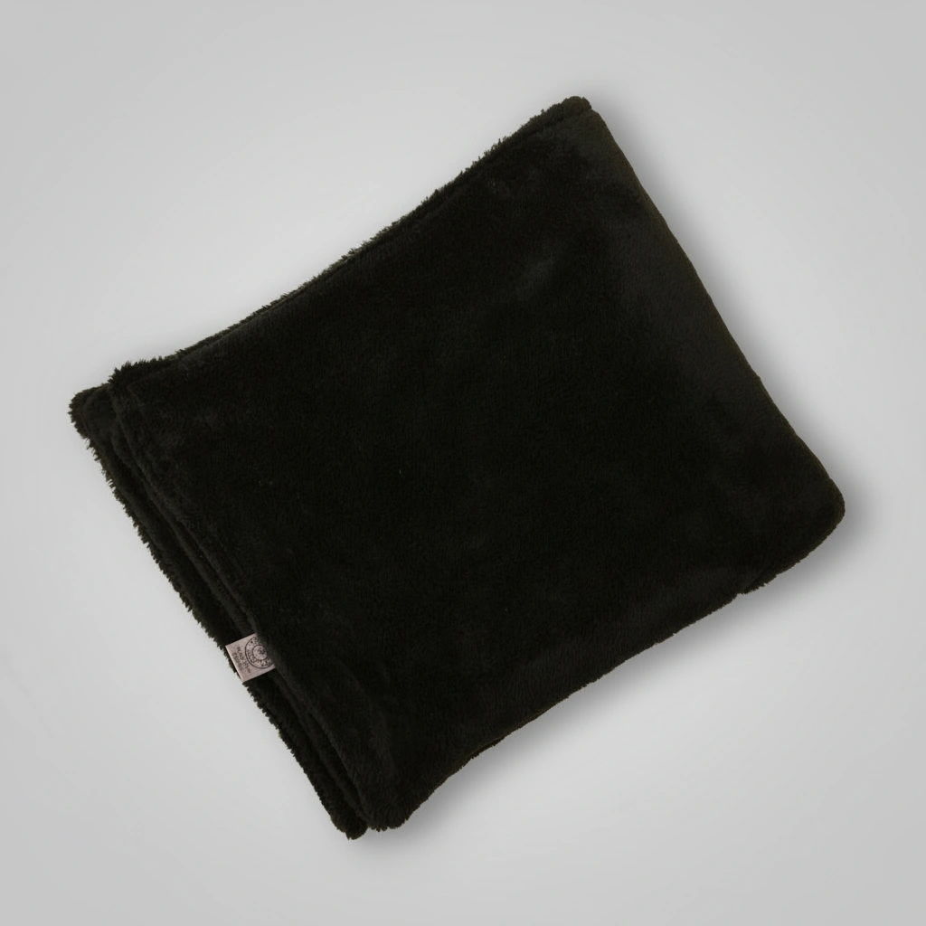 Folded black blanket on a light gray background