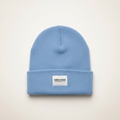 Blue beanie with a white label on a light beige background