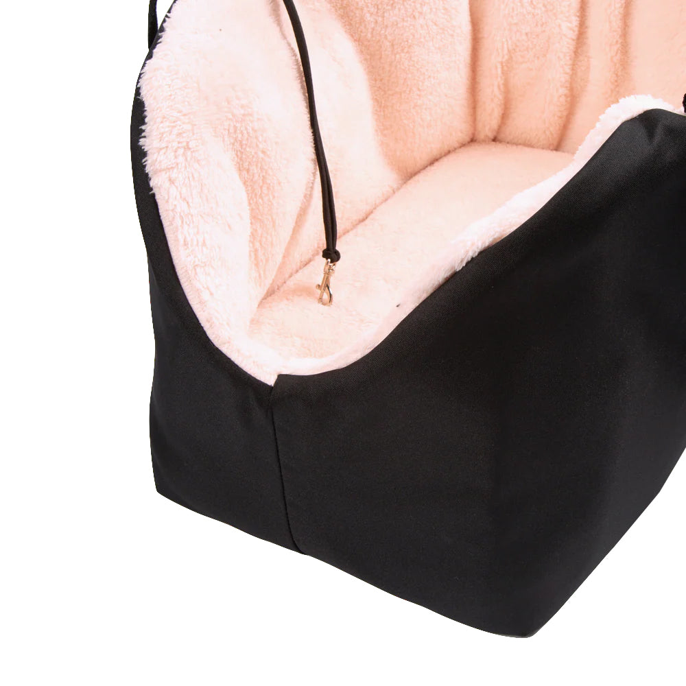 Black pet bed with pink cushion on a white background