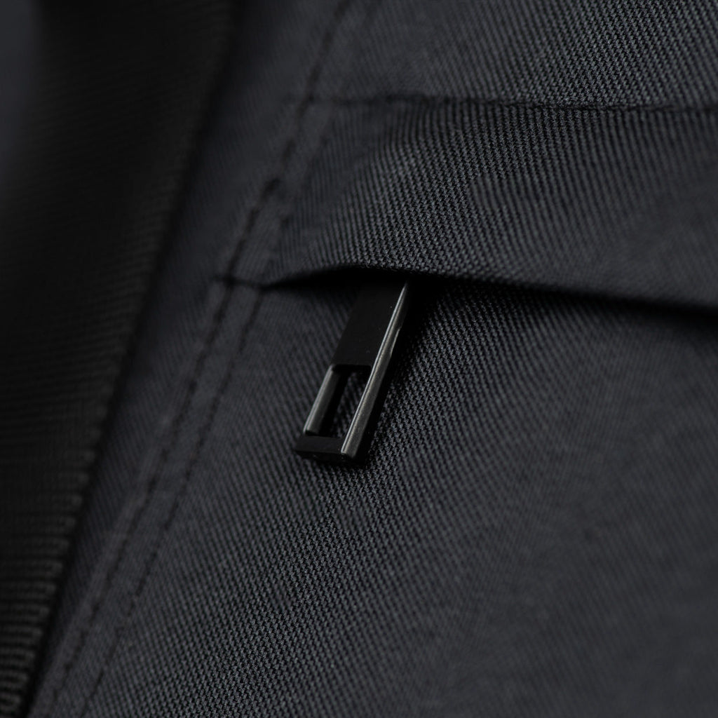 Close-up of a black zipper on a textured black fabric surface