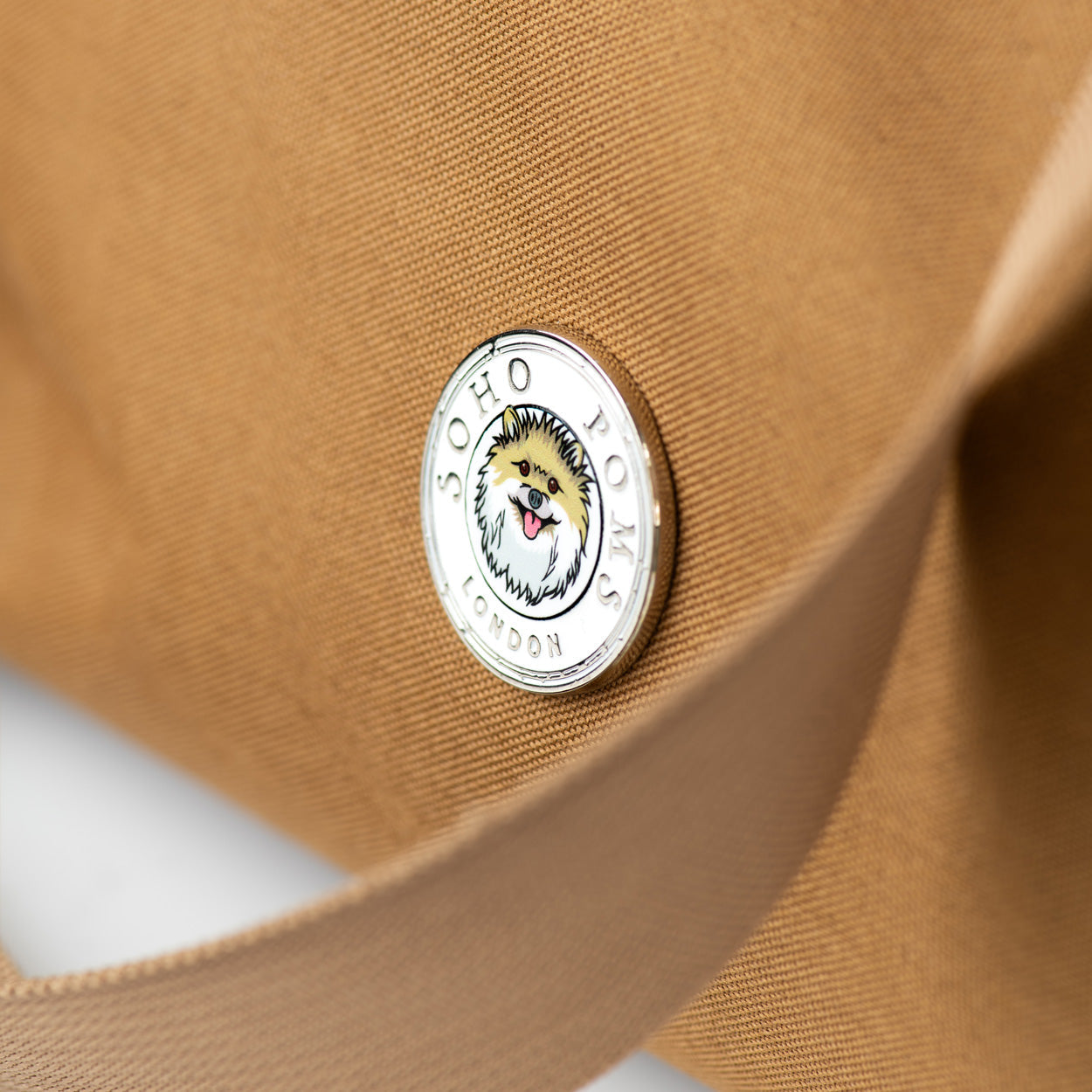 Close-up of a brown bag with a brand logo on a white background