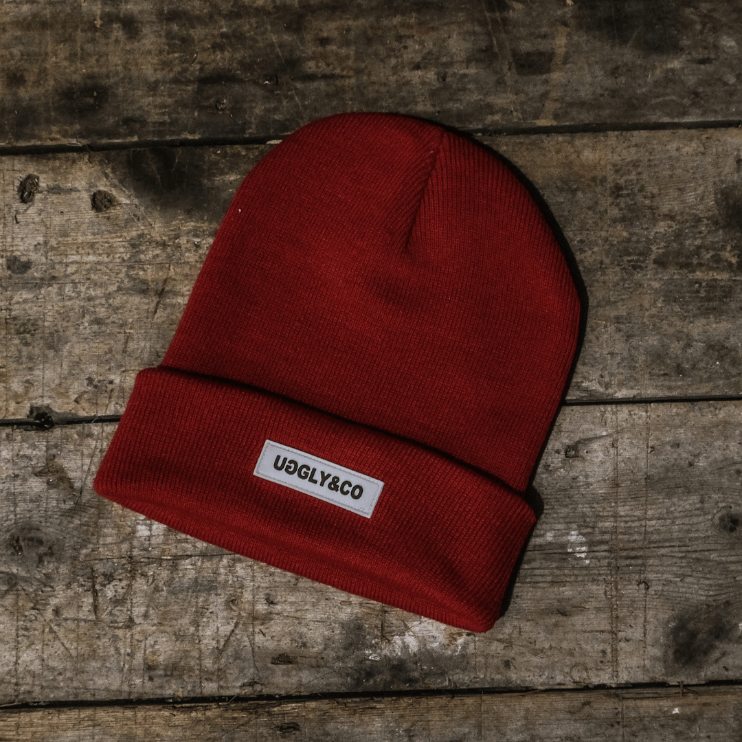 Red beanie with a label on a wooden surface