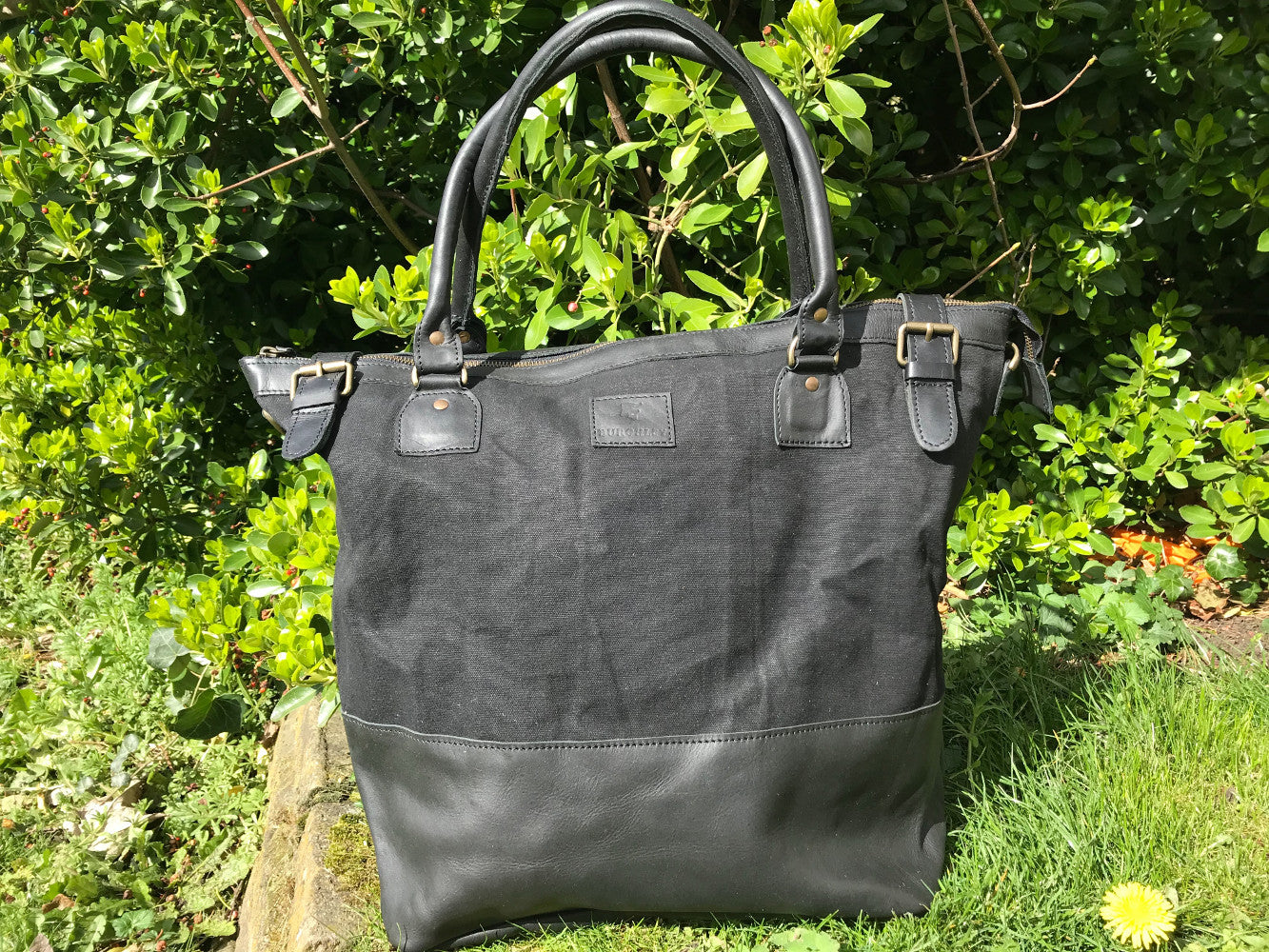 The Bingham.  A classic zipped tote bag by Burghley Bags.  Handmade from eco-friendly vegetable tanned leather and strong cotton canvas, with a leather shoulder strap.  Shown in elegant black.