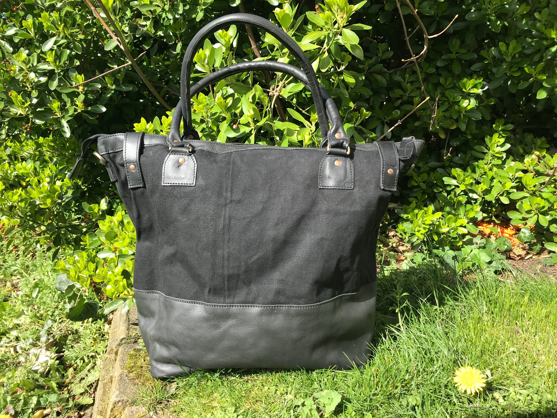 The Bingham.  A classic zipped tote bag by Burghley Bags.  Handmade from eco-friendly vegetable tanned leather and strong cotton canvas, with a leather shoulder strap.  Shown in elegant black.